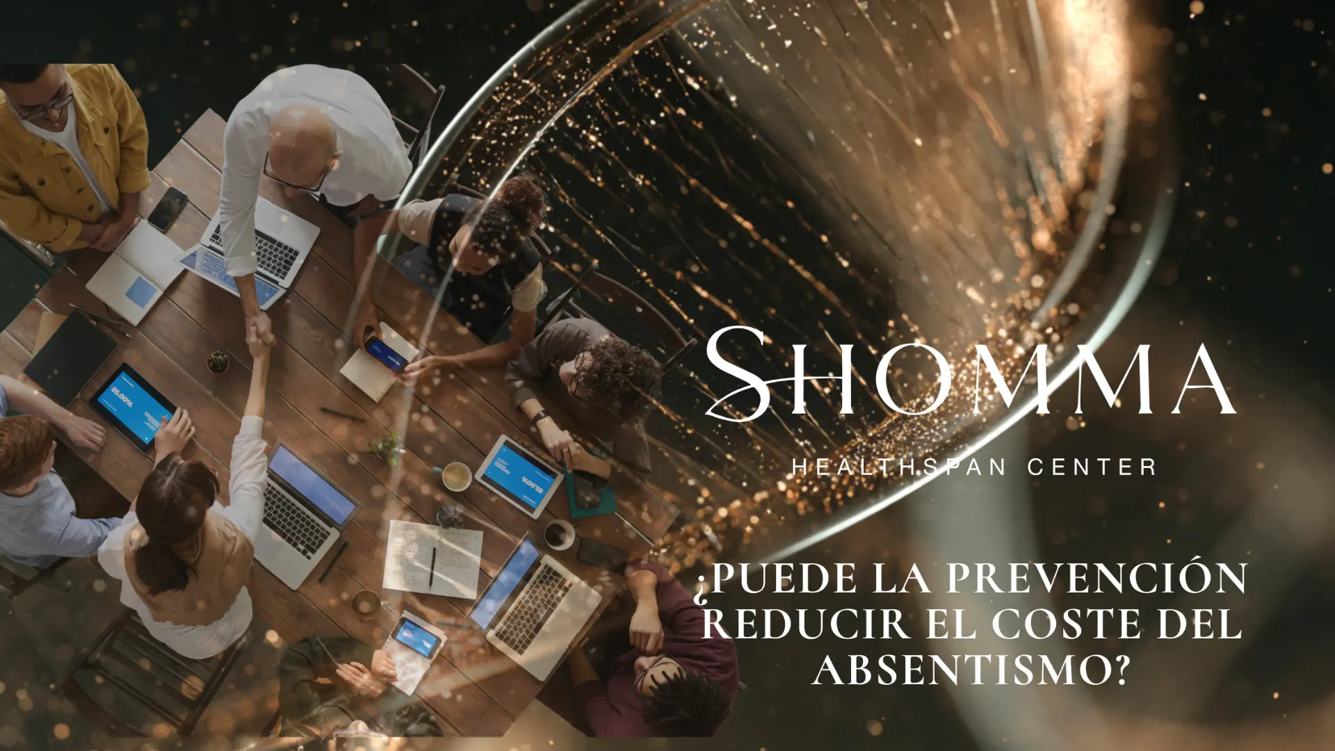 Overhead view of a work meeting, two hands clasped on the table amid golden light trails: can prevention reduce the cost of absenteeism? | SHOMMA Healthspan Center
